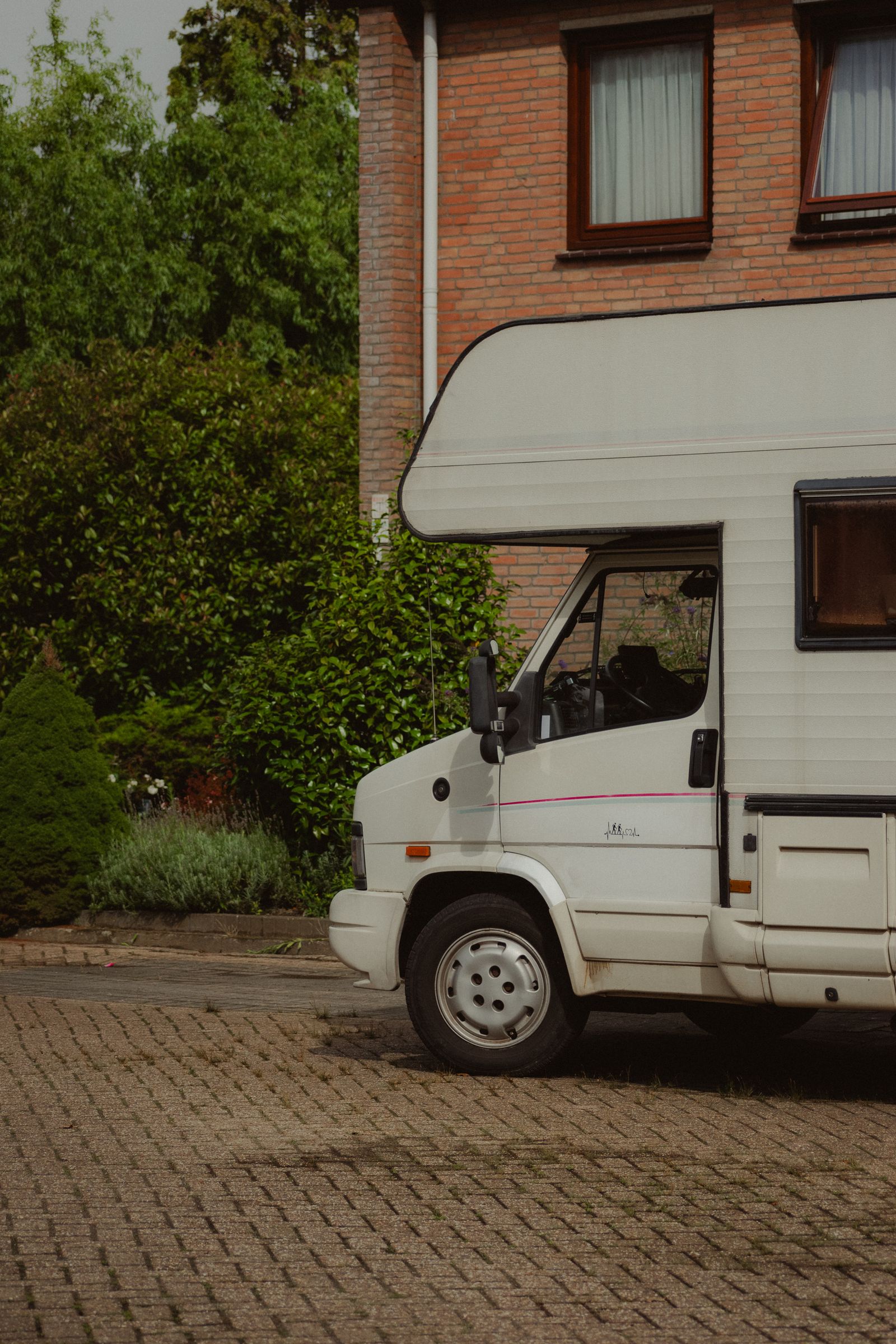 Camper geparkeerd naast een bakstenen gebouw in de stad