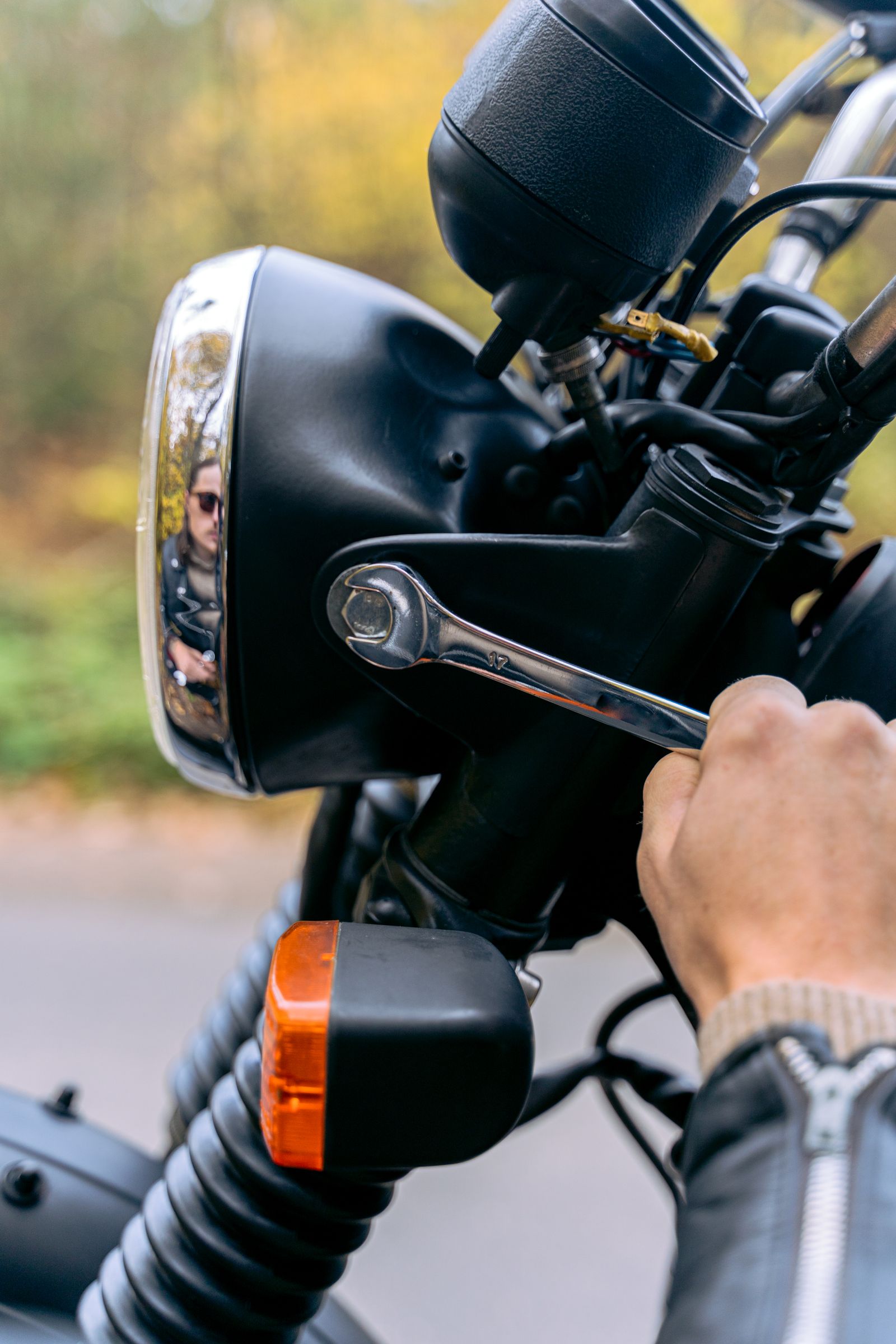 Hand draait met gereedschap bouten vast aan een motorfiets tijdens onderhoud